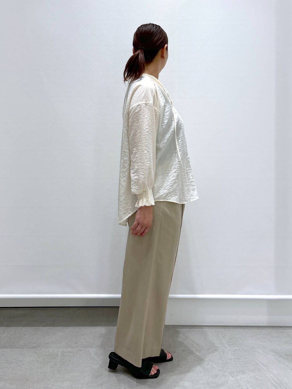 ベージュ系のその他パンツ、ブラック系のショルダーバッグ、ホワイト系のシャツ/ブラウスを着用したレディースの春コーディネートの5枚目の写真