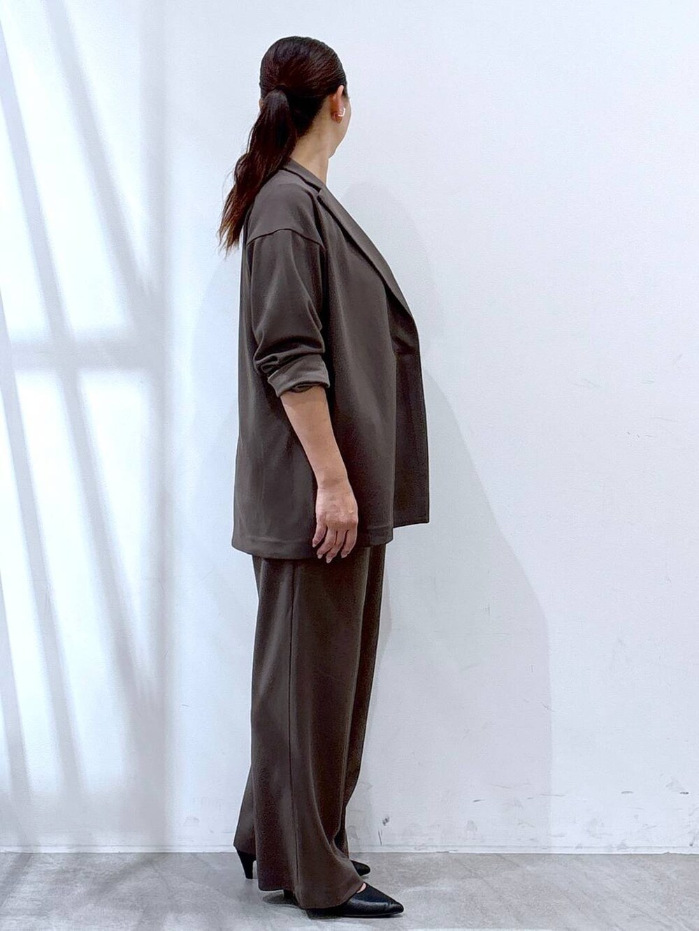 ブラック系のパンプス、ブラック系のハンドバッグ、ブラウン系のその他パンツを着用したレディースの秋コーディネートの5枚目の写真