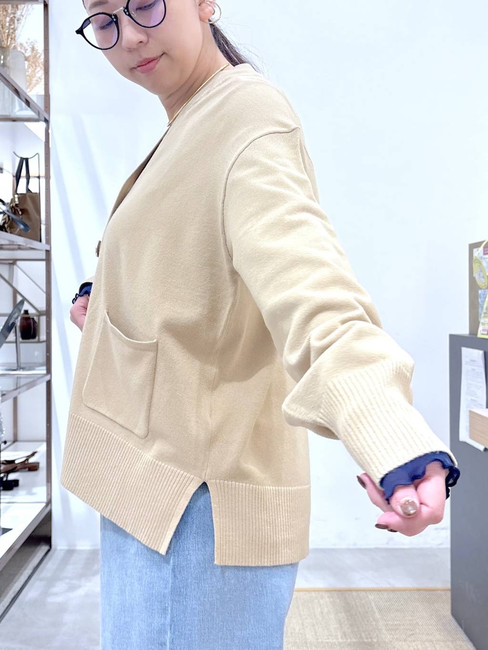 ブラック系のパンプス、ブルー系のデニムパンツ、ゴールド系のネックレスを着用したレディースの冬コーディネートの7枚目の写真