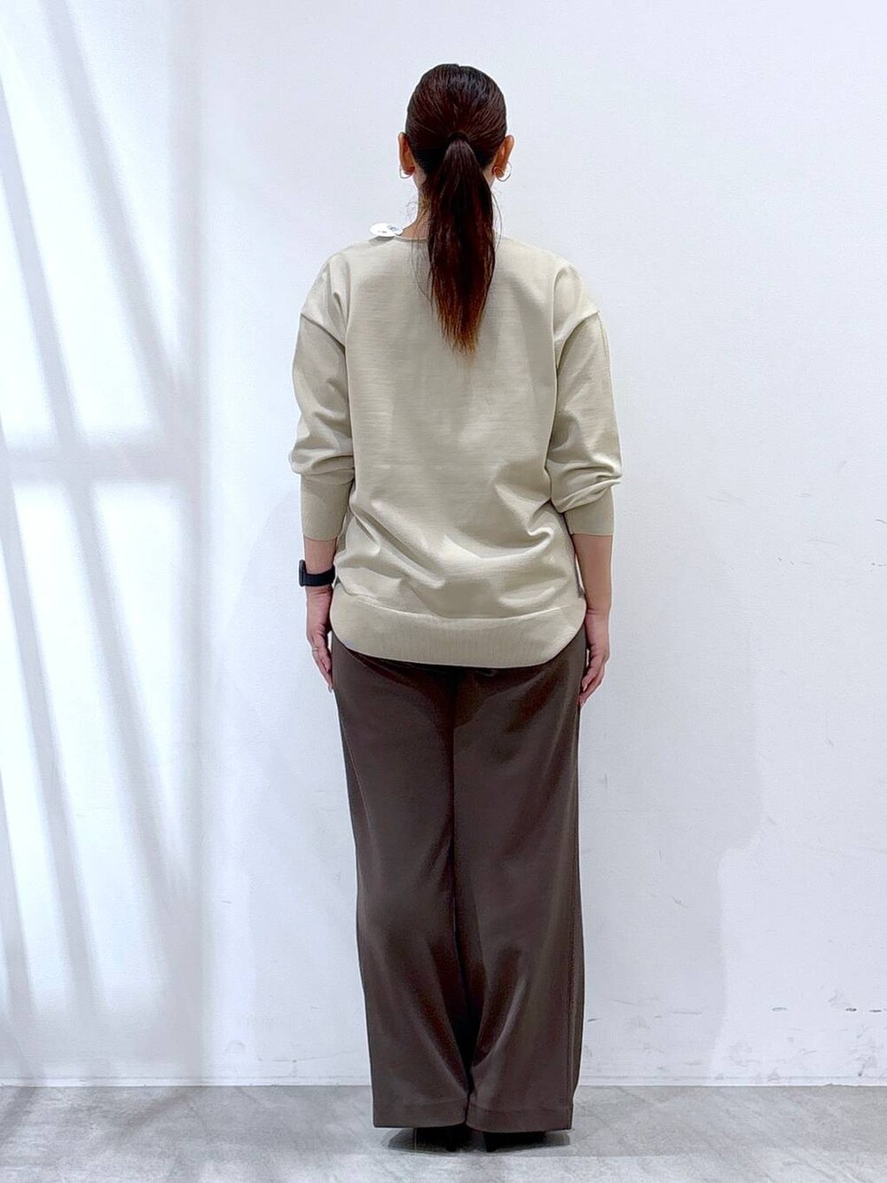 ブラック系のパンプス、ブラック系のハンドバッグ、ブラウン系のその他パンツを着用したレディースの秋コーディネートの4枚目の写真