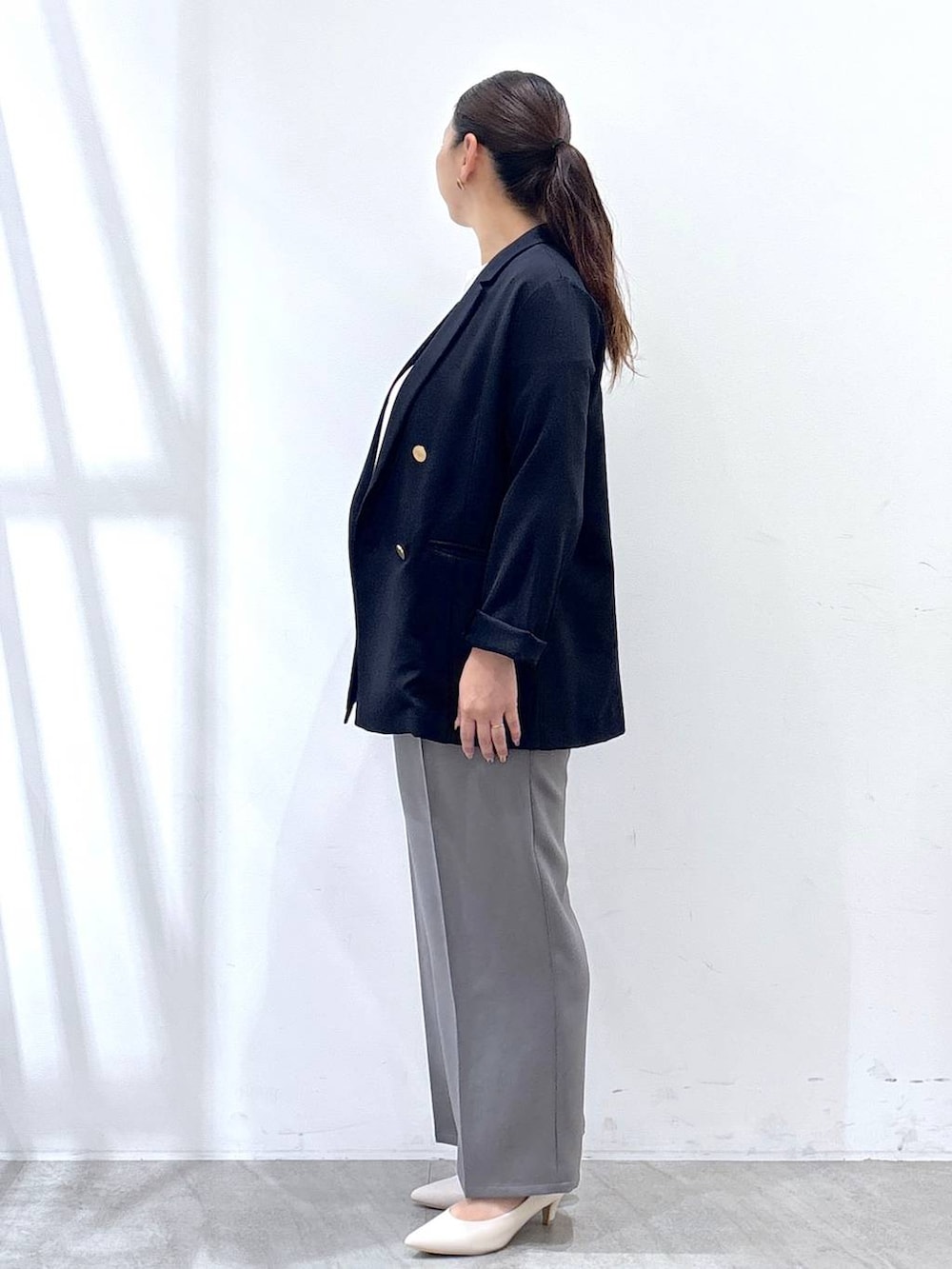 ホワイト系のパンプス、グレー系のその他パンツ、ブルー系のテーラードジャケットを着用したレディースの秋コーディネートの3枚目の写真