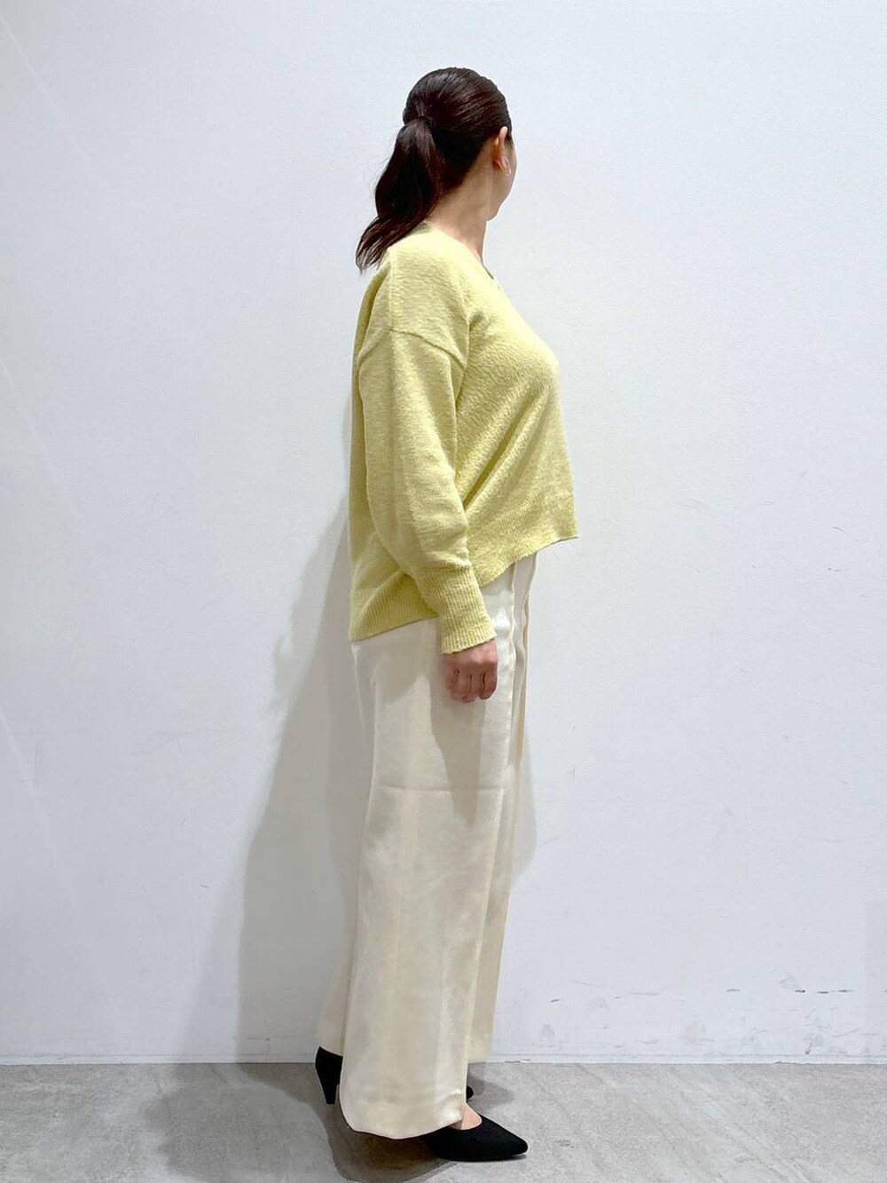 ブラック系のトートバッグ、イエロー系のニット/セーター、ホワイト系のその他パンツを着用したレディースの冬コーディネートの5枚目の写真