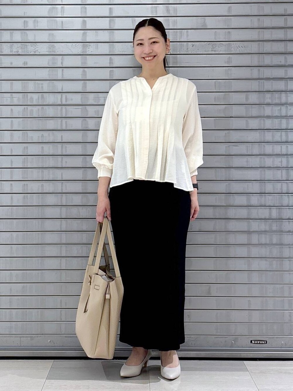 ベージュ系のトートバッグ、ホワイト系のシャツ/ブラウスを着用したレディースの春コーディネートの2枚目の写真