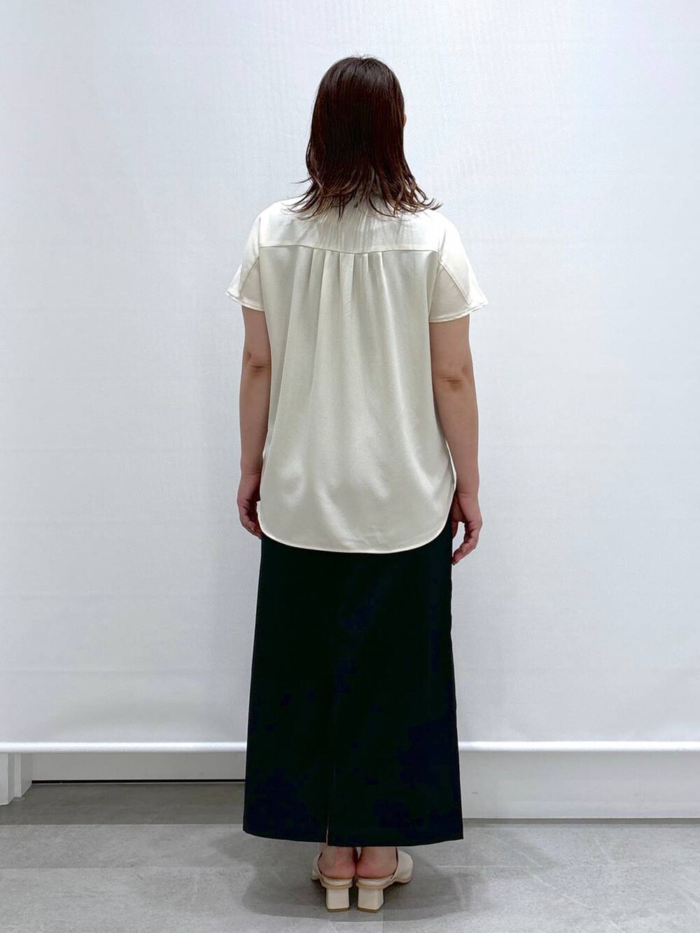 ホワイト系のシャツ/ブラウス、ホワイト系のサンダル、ブラック系のスカートを着用したレディースの夏コーディネートの4枚目の写真