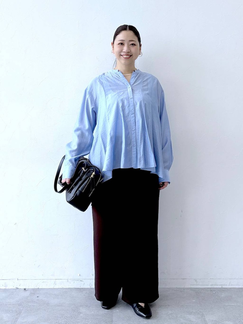 ブラック系のパンプス、ブラック系のボストンバッグ、ブラウン系のその他パンツを着用したレディースの冬コーディネートの2枚目の写真