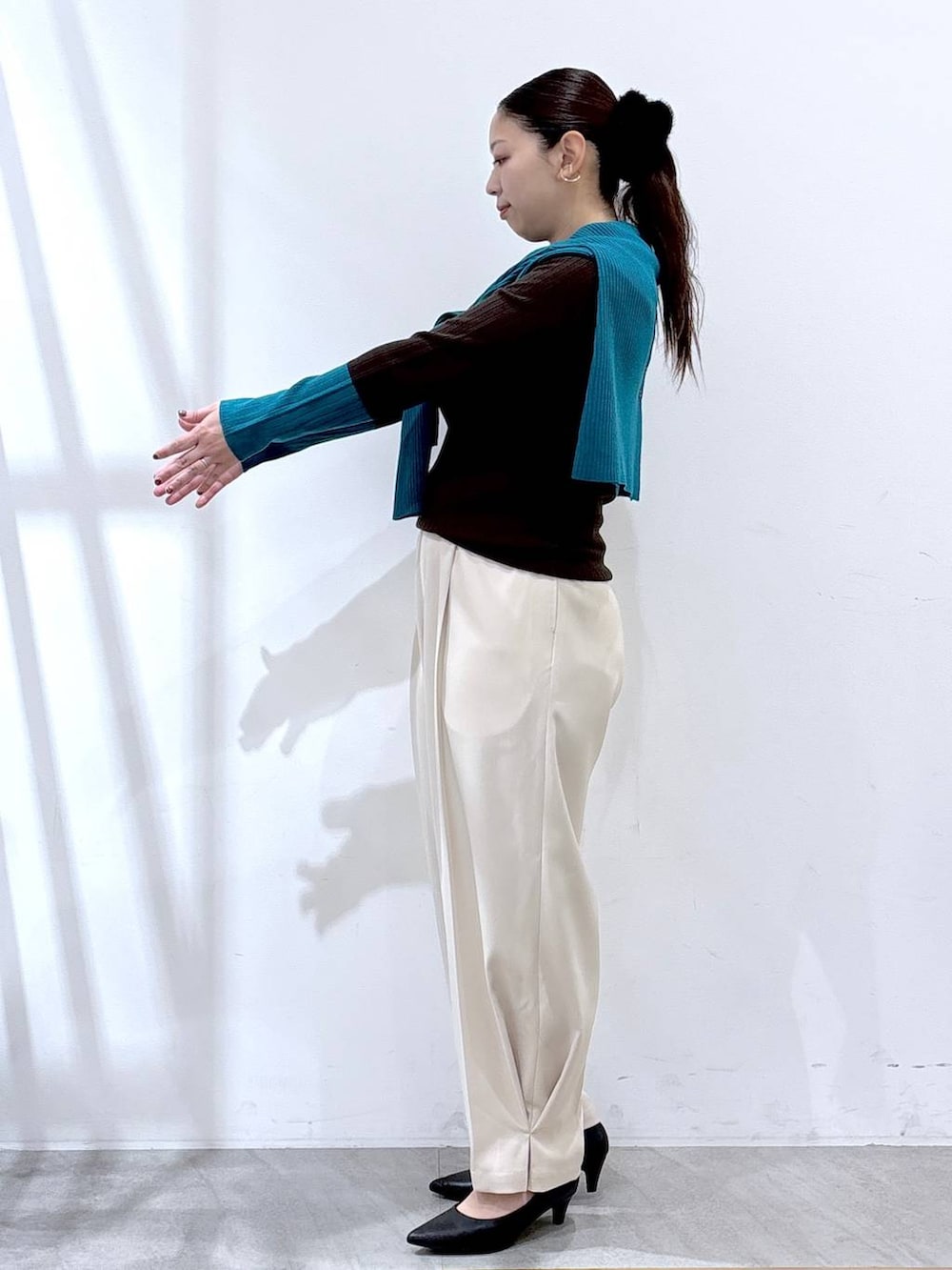 ブラック系のパンプス、ブラック系のボストンバッグ、ブラウン系のニット/セーターを着用したレディースの冬コーディネートの4枚目の写真