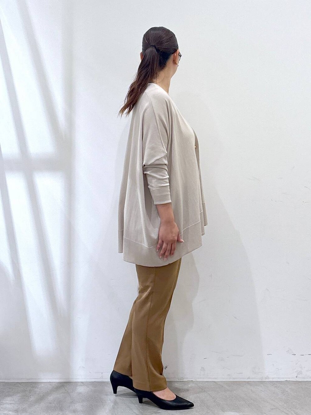 ブラック系のパンプス、ベージュ系のカーディガン/ボレロ、イエロー系のその他パンツを着用したレディースの秋コーディネートの5枚目の写真