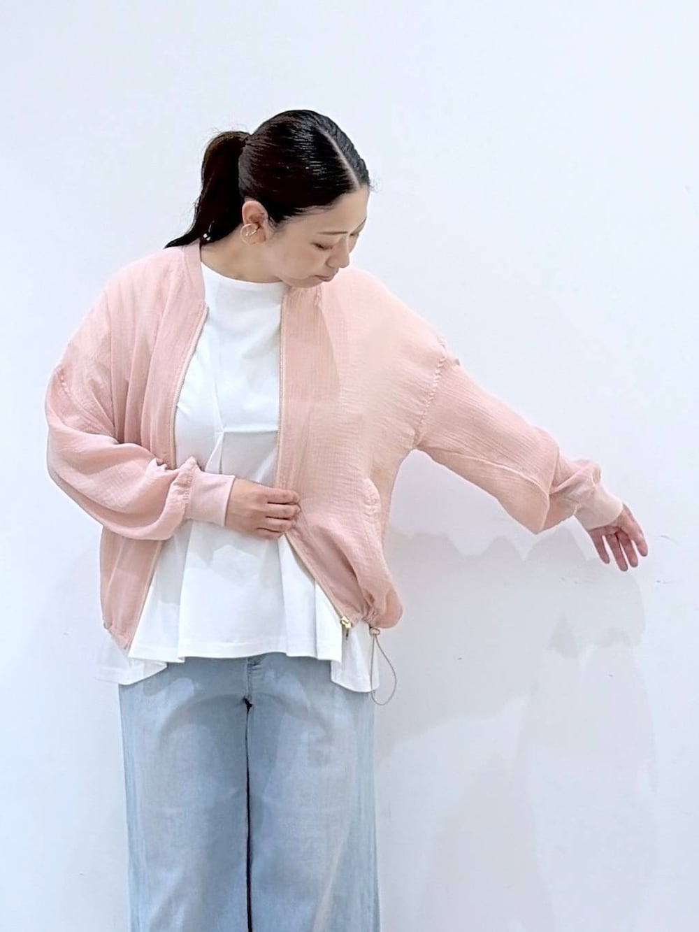 ブラウン系のサンダル、ホワイト系のTシャツ/カットソー、ブルー系のデニムパンツを着用したレディースの夏コーディネートの6枚目の写真