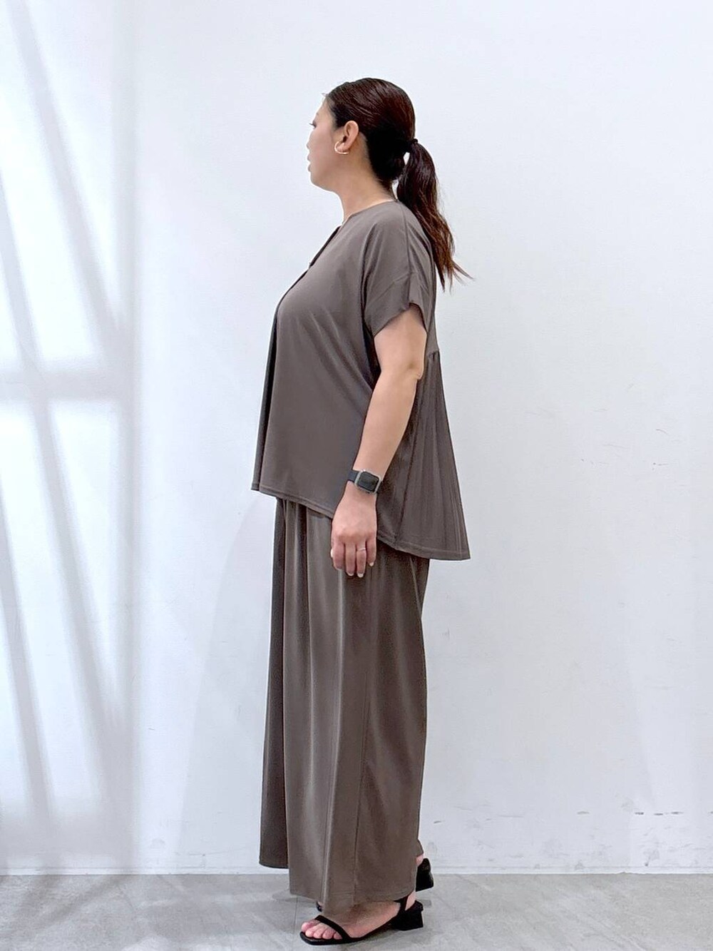 ブラック系のハンドバッグ、グリーン系のその他パンツ、グリーン系のTシャツ/カットソーを着用したレディースの夏コーディネートの3枚目の写真