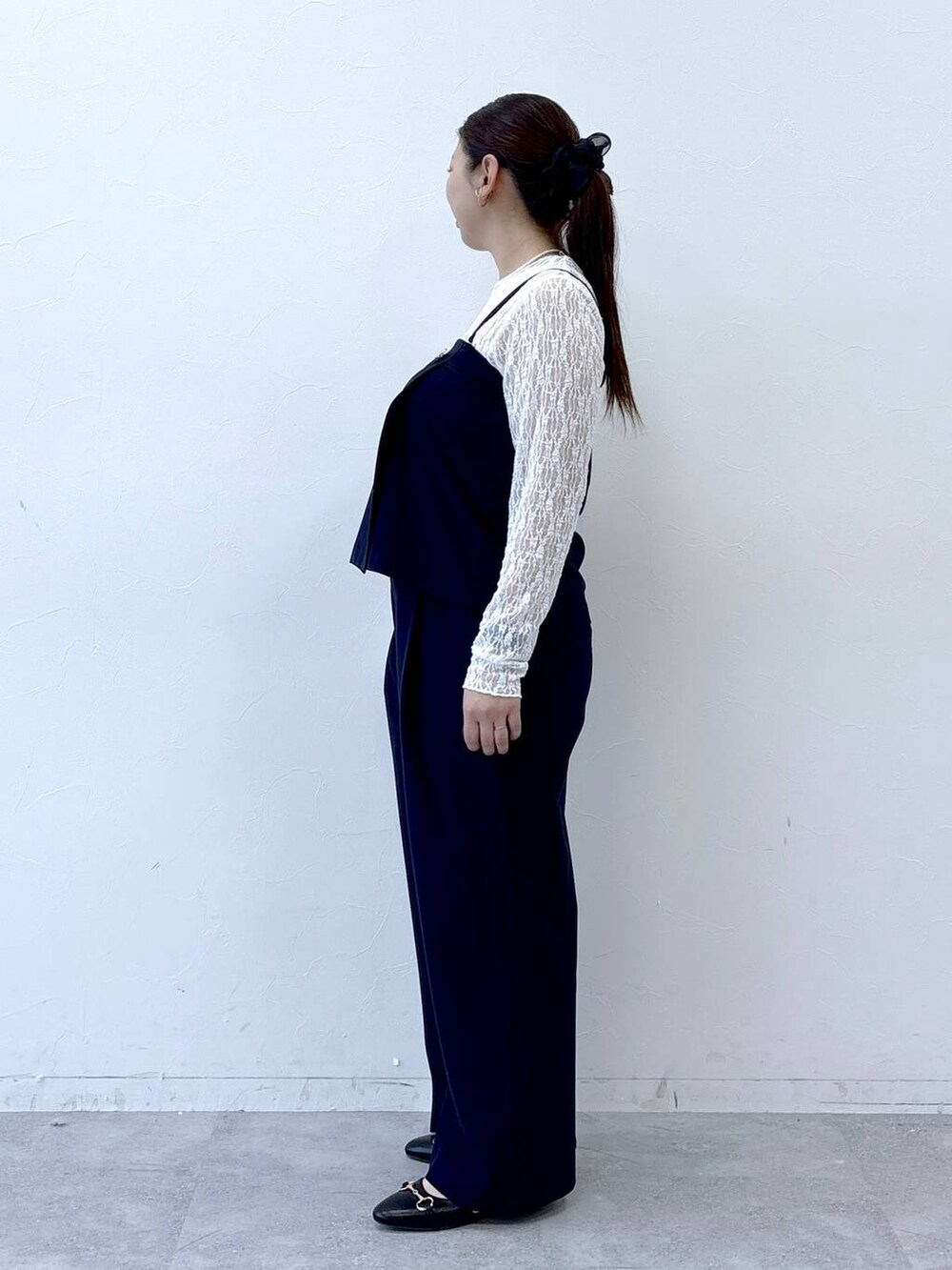 ブラック系のパンプス、ブラック系のトートバッグ、ブルー系のその他パンツを着用したレディースの冬コーディネートの3枚目の写真