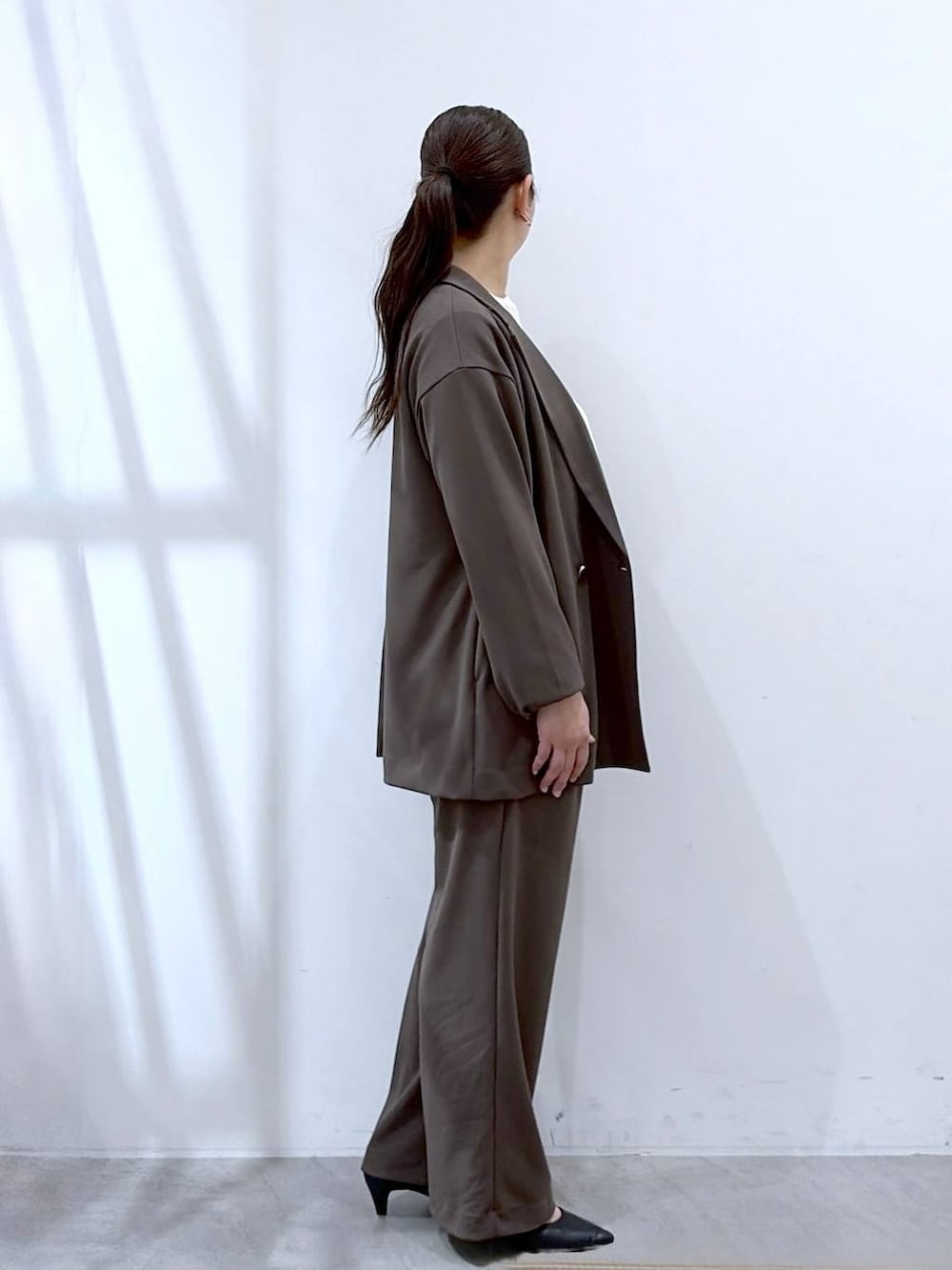 ブラウン系のその他パンツ、ブラック系のハンドバッグ、ブラウン系のテーラードジャケットを着用したレディースの春コーディネートの5枚目の写真