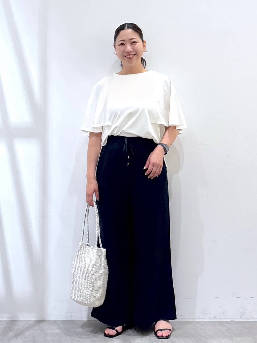 ブルー系のその他パンツ、ブラック系のサンダル、シルバー系のトートバッグを着用したレディースの夏コーディネートの2枚目の写真