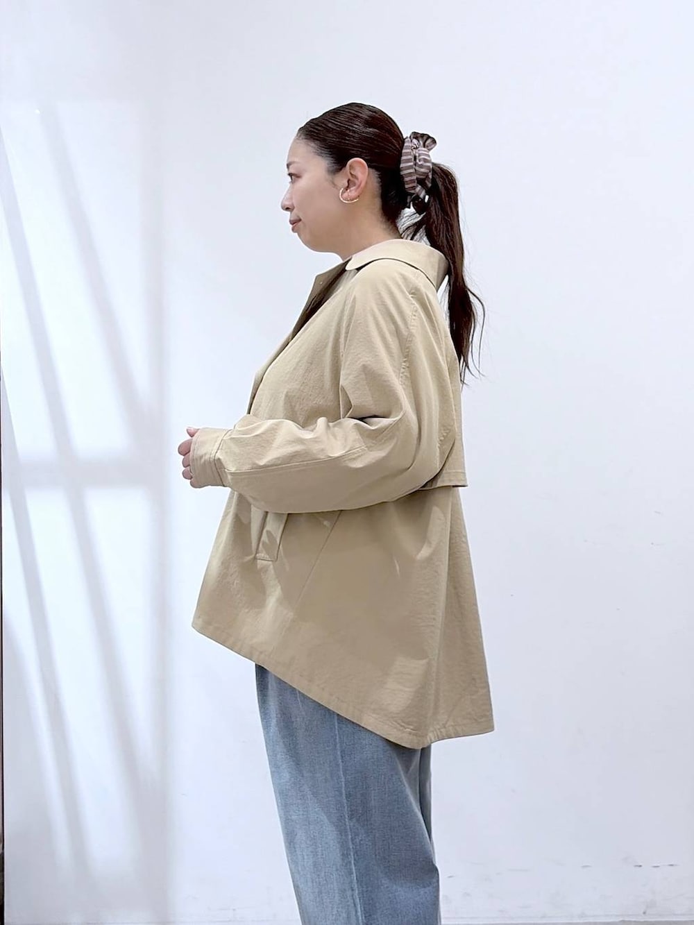 ホワイト系のニット/セーター、ブルー系のデニムパンツ、ブラック系のハンドバッグを着用したレディースの春コーディネートの8枚目の写真