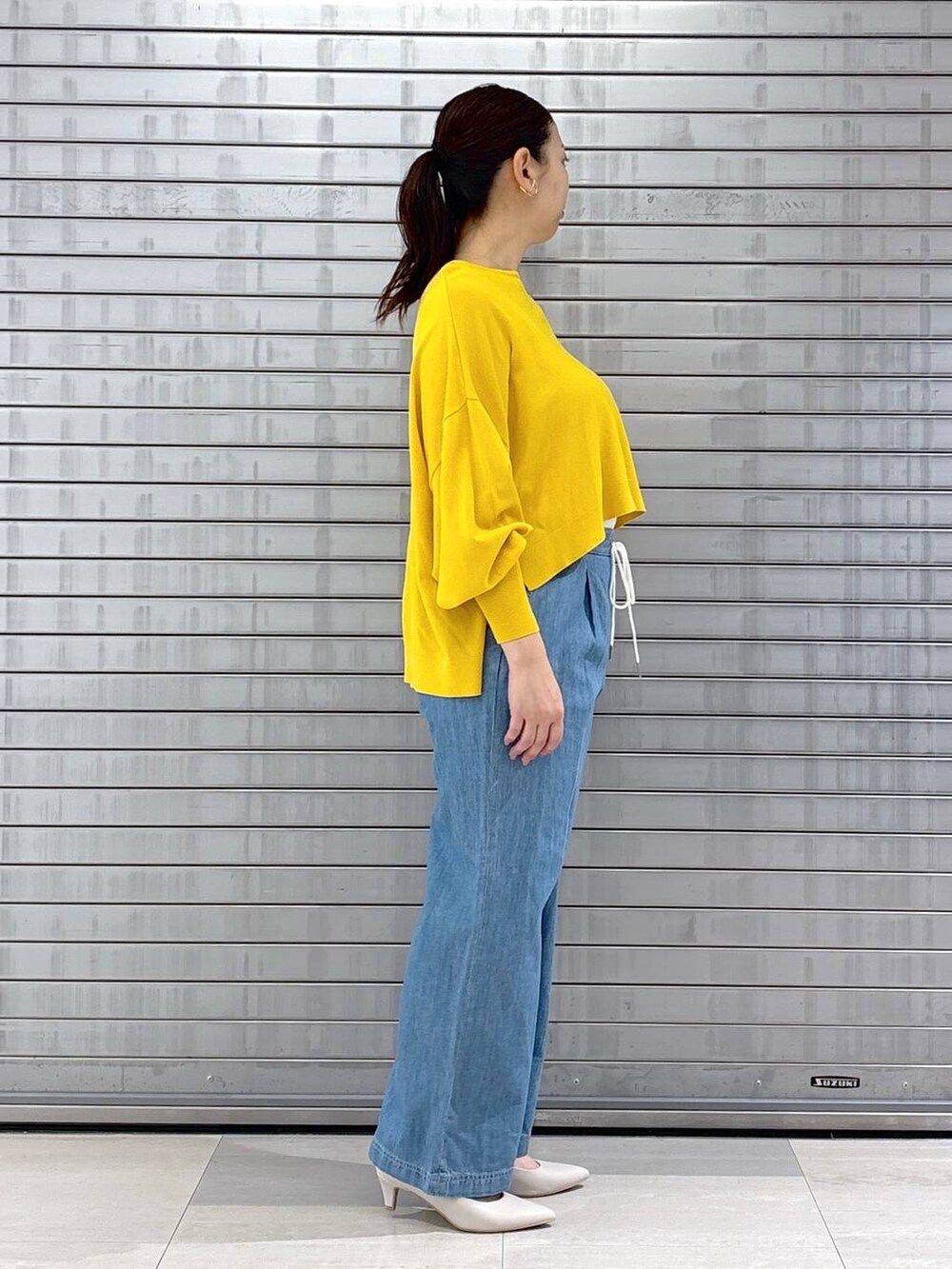 ホワイト系のハンドバッグ、イエロー系のニット/セーターを着用したレディースの春コーディネートの5枚目の写真