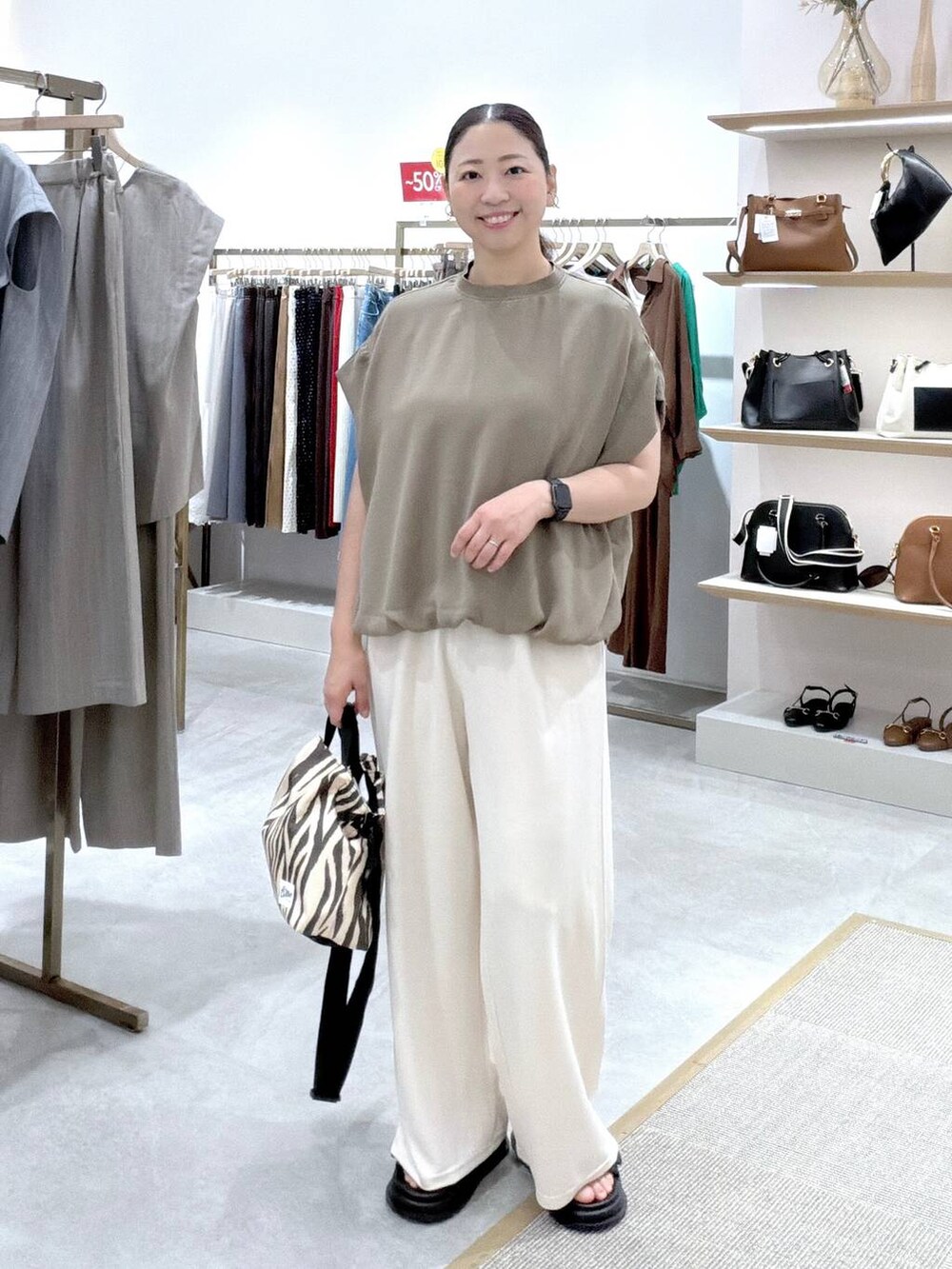 ホワイト系のその他パンツ、グリーン系のTシャツ/カットソー、ホワイト系のトートバッグを着用したレディースの夏コーディネートの2枚目の写真
