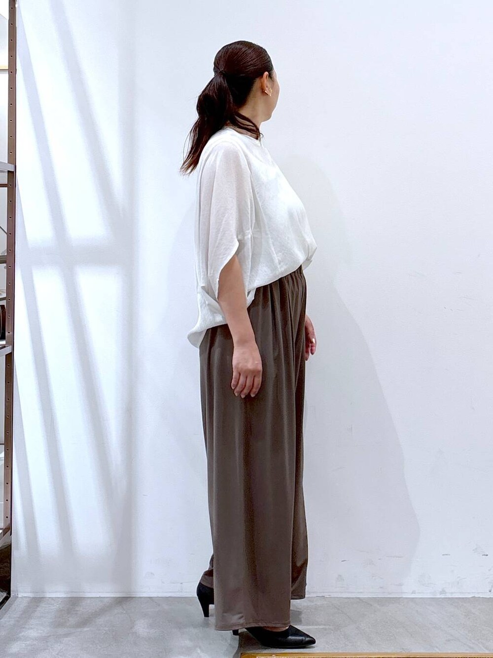 ブラック系のパンプス、ホワイト系のTシャツ/カットソー、ブラック系のハンドバッグを着用したレディースの夏コーディネートの5枚目の写真