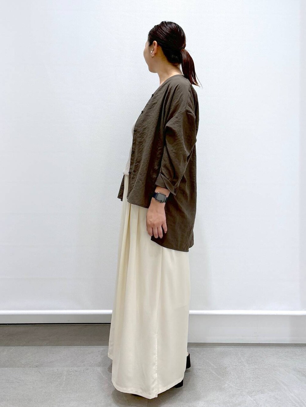 ブラウン系のシャツ/ブラウス、ホワイト系のその他パンツ、ブラック系のハンドバッグを着用したレディースの夏コーディネートの3枚目の写真