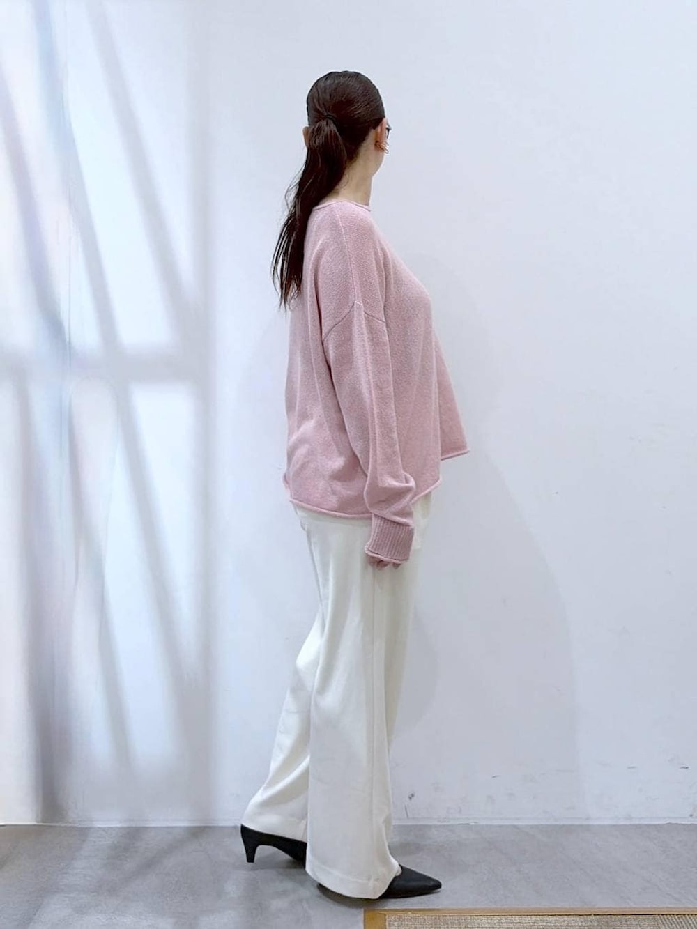 ブラック系のその他パンツ、ピンク系のニット/セーター、ブラック系のハンドバッグを着用したレディースの春コーディネートの5枚目の写真