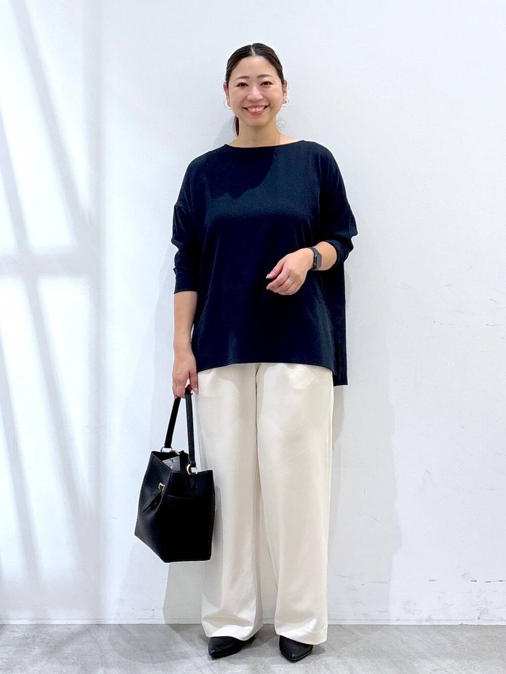 ブラック系のパンプス、ブルー系のシャツ/ブラウス、ブラック系のショルダーバッグを着用したレディースの秋コーディネートの2枚目の写真