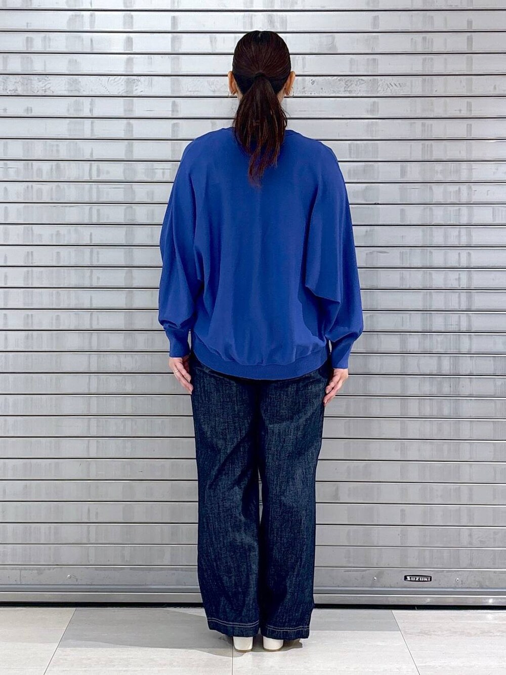 ブルー系のカーディガン/ボレロ、ブルー系のニット/セーター、ブルー系のデニムパンツを着用したレディースの春コーディネートの4枚目の写真