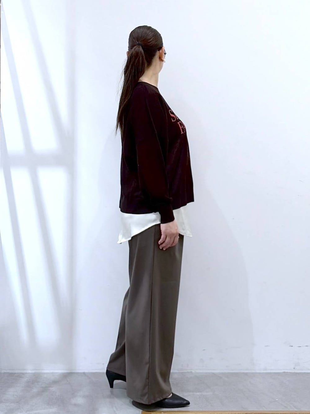 ブラック系のハンドバッグ、グリーン系のその他パンツ、ホワイト系のタンクトップを着用したレディースの春コーディネートの5枚目の写真