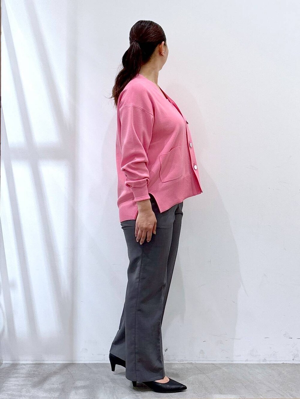 ブラック系のパンプス、ピンク系のカーディガン/ボレロ、グレー系のその他パンツを着用したレディースの秋コーディネートの5枚目の写真