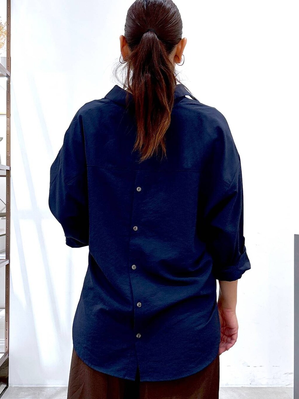 ブラック系のパンプス、ブラウン系のその他パンツ、ブルー系のシャツ/ブラウスを着用したレディースの秋コーディネートの6枚目の写真