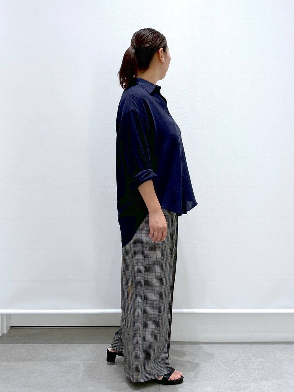 ブラック系のトートバッグ、ブラック系のサンダル、ブルー系のシャツ/ブラウスを着用したレディースの夏コーディネートの5枚目の写真