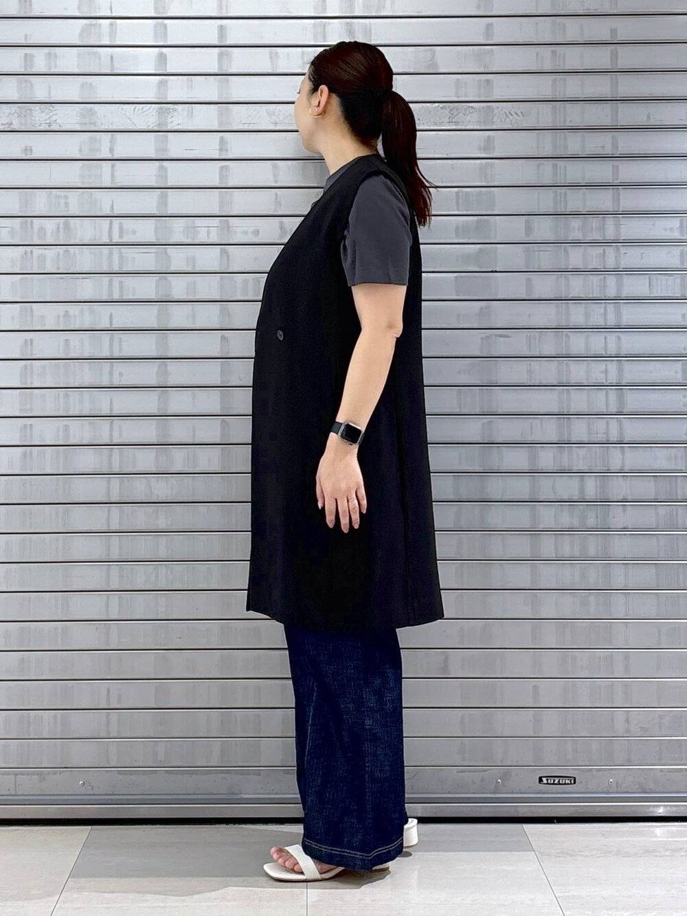 グレー系のTシャツ/カットソー、ブルー系のデニムパンツ、ホワイト系のハンドバッグを着用したレディースの春コーディネートの3枚目の写真