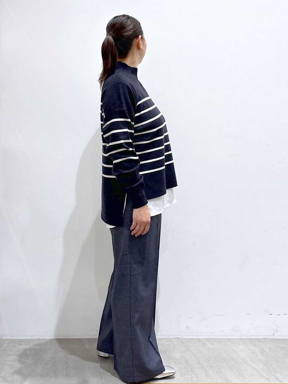 シルバー系のローファー、ブルー系のニット/セーター、ブルー系のデニムパンツを着用したレディースの秋コーディネートの5枚目の写真