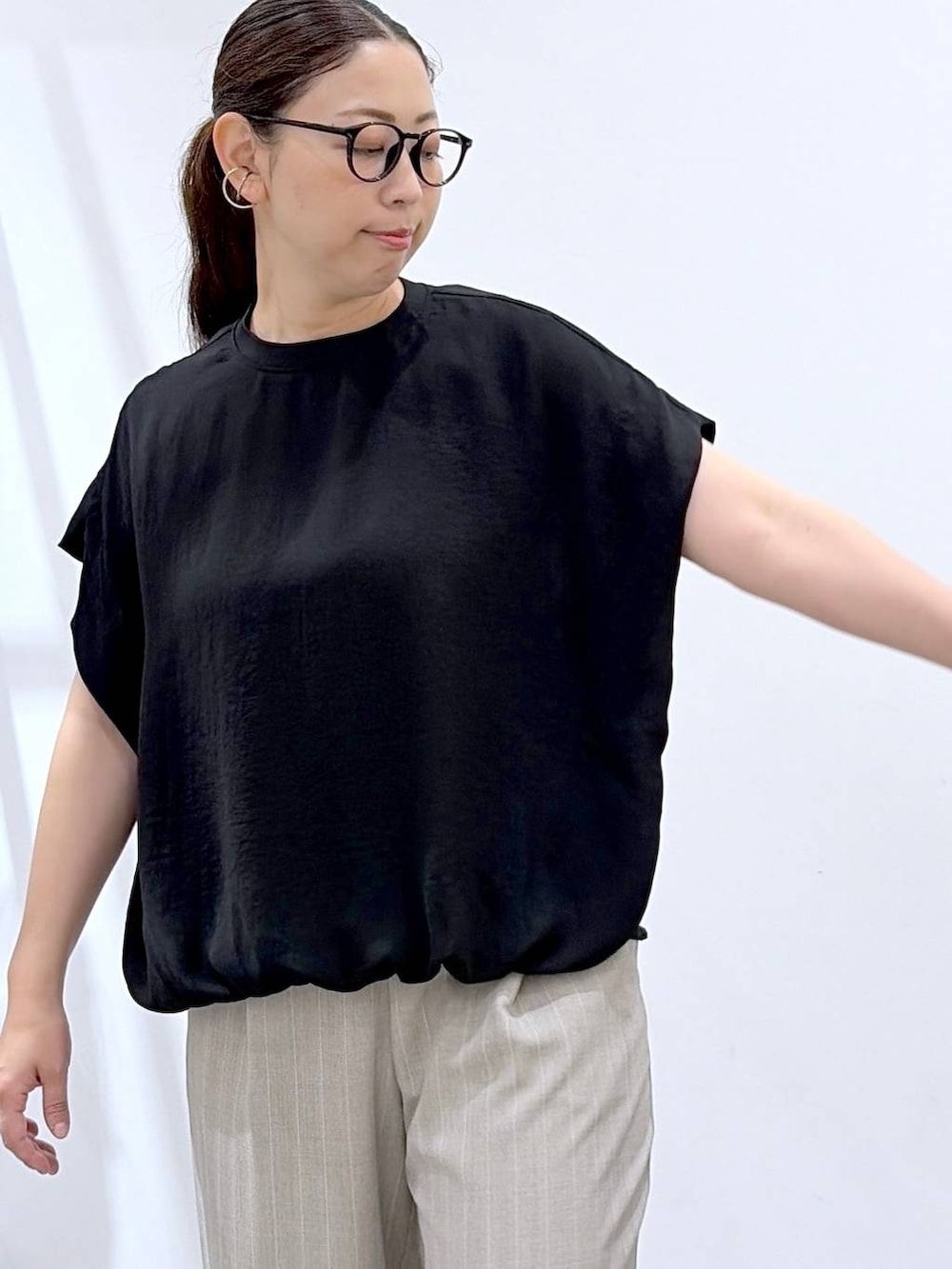ブラック系のTシャツ/カットソー、ブラック系のサンダル、ブラック系のかごバッグを着用したレディースの夏コーディネートの6枚目の写真