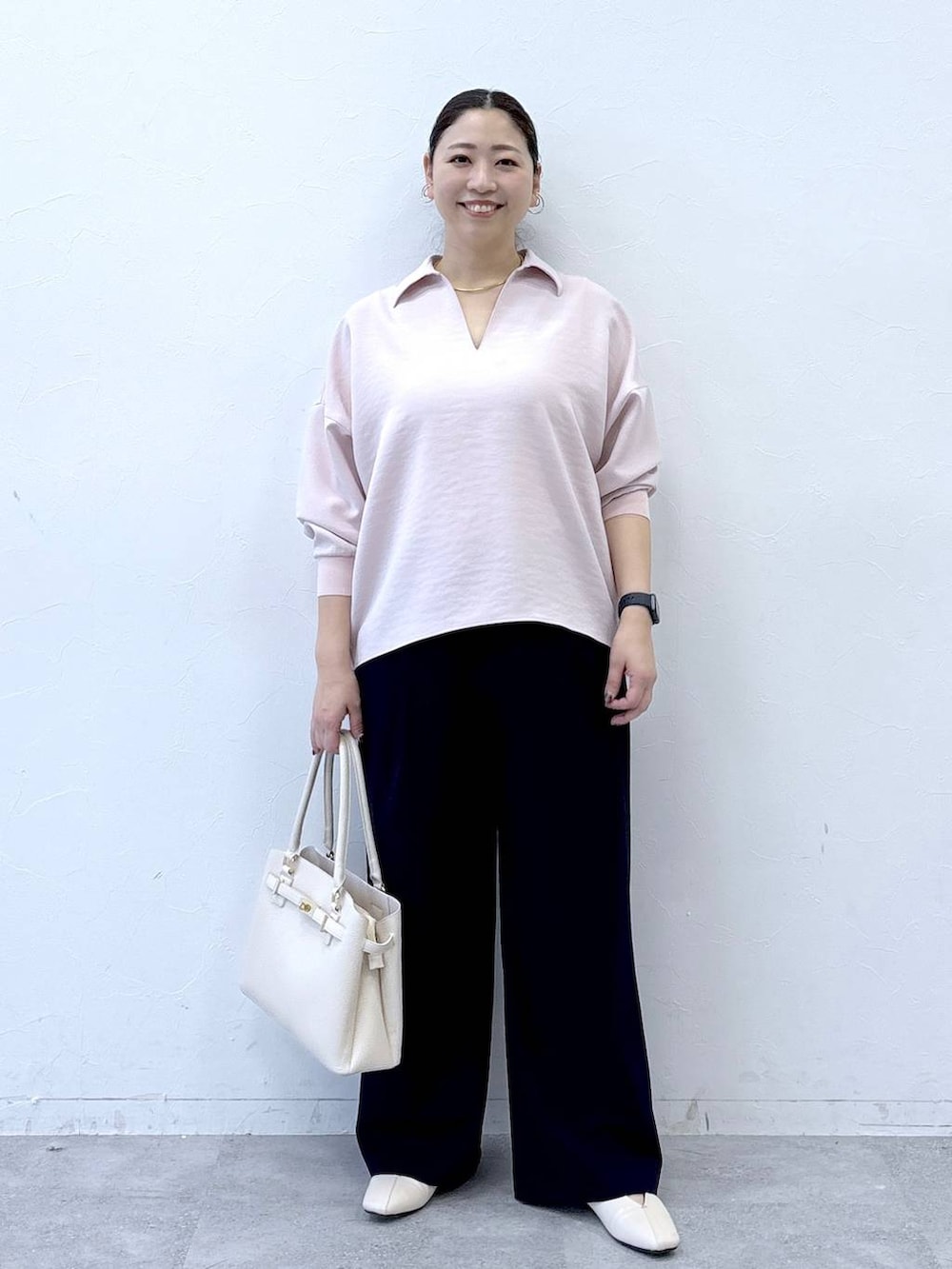 ホワイト系のパンプス、ホワイト系のハンドバッグ、ブルー系のその他パンツを着用したレディースの冬コーディネートの2枚目の写真