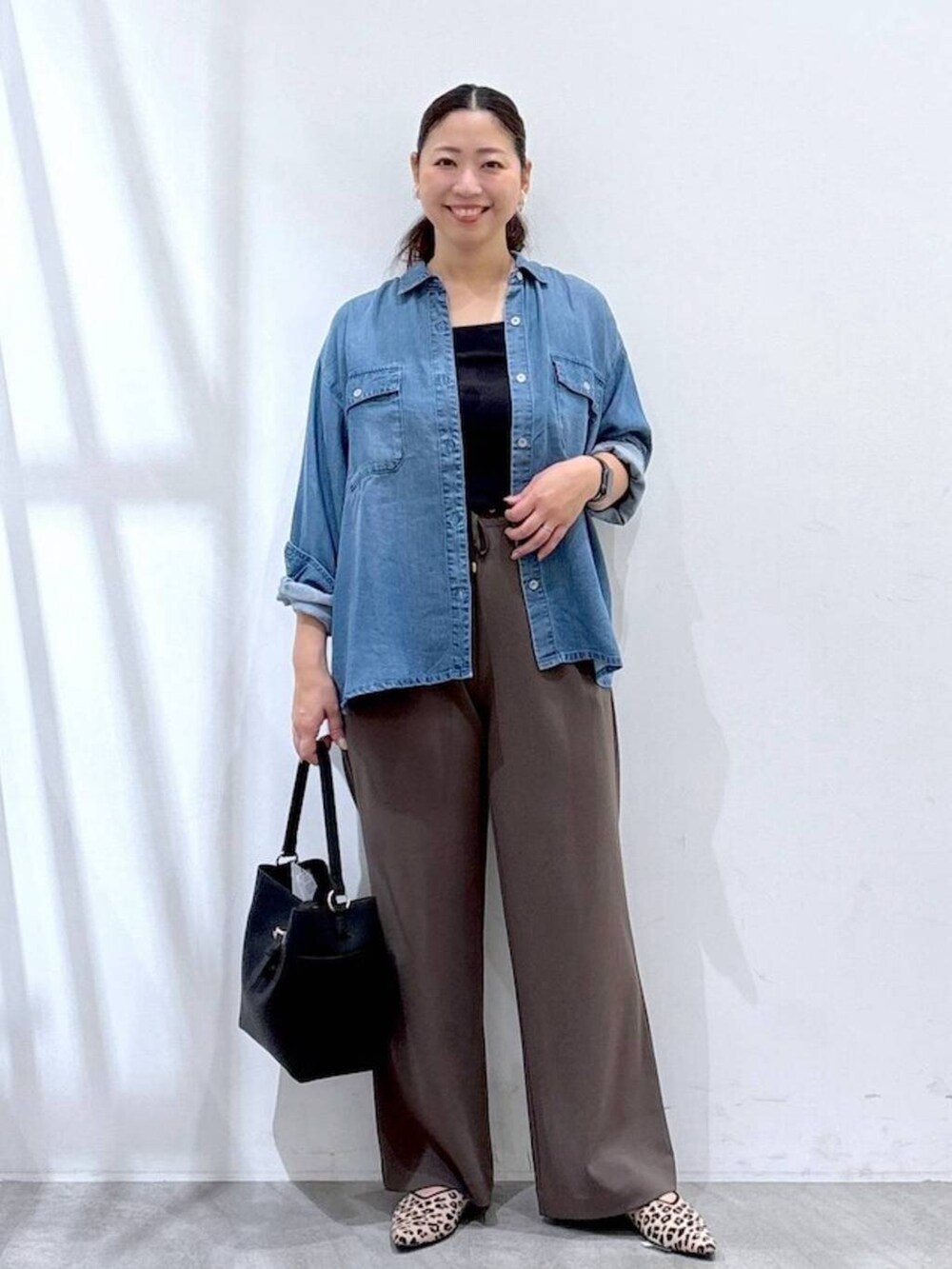 ブラック系のショルダーバッグ、ブルー系のシャツ/ブラウス、ブラウン系のその他パンツを着用したレディースの秋コーディネートの2枚目の写真