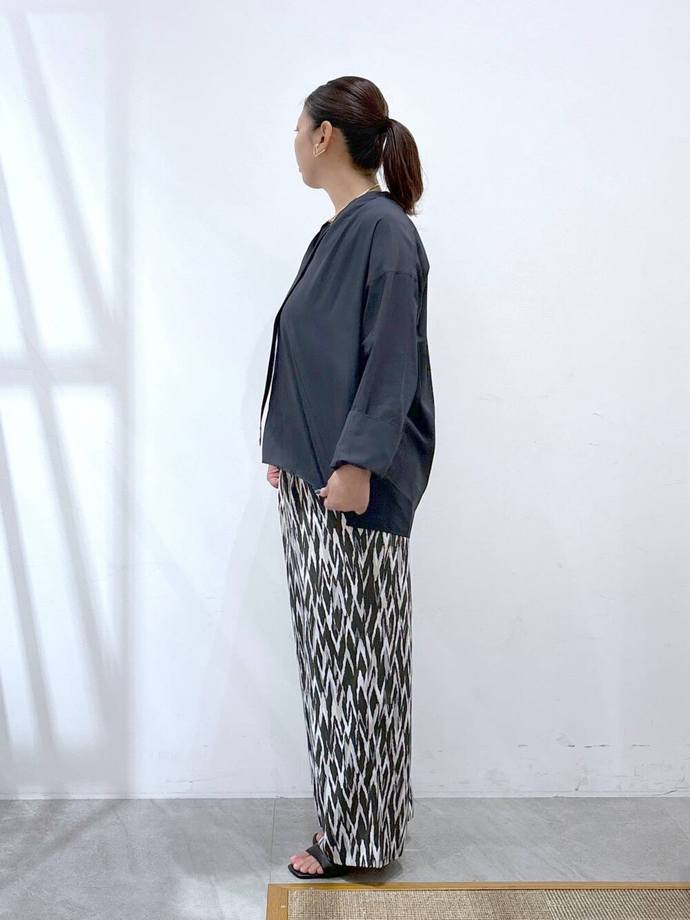 ブルー系のシャツ/ブラウス、ブラック系のトートバッグ、ブラック系のその他パンツを着用したレディースの秋コーディネートの3枚目の写真