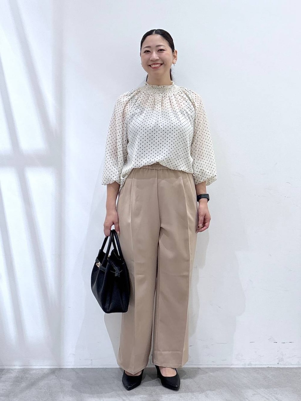 ブラック系のパンプス、ブラック系のカーディガン/ボレロ、ブラック系のハンドバッグを着用したレディースの秋コーディネートの3枚目の写真