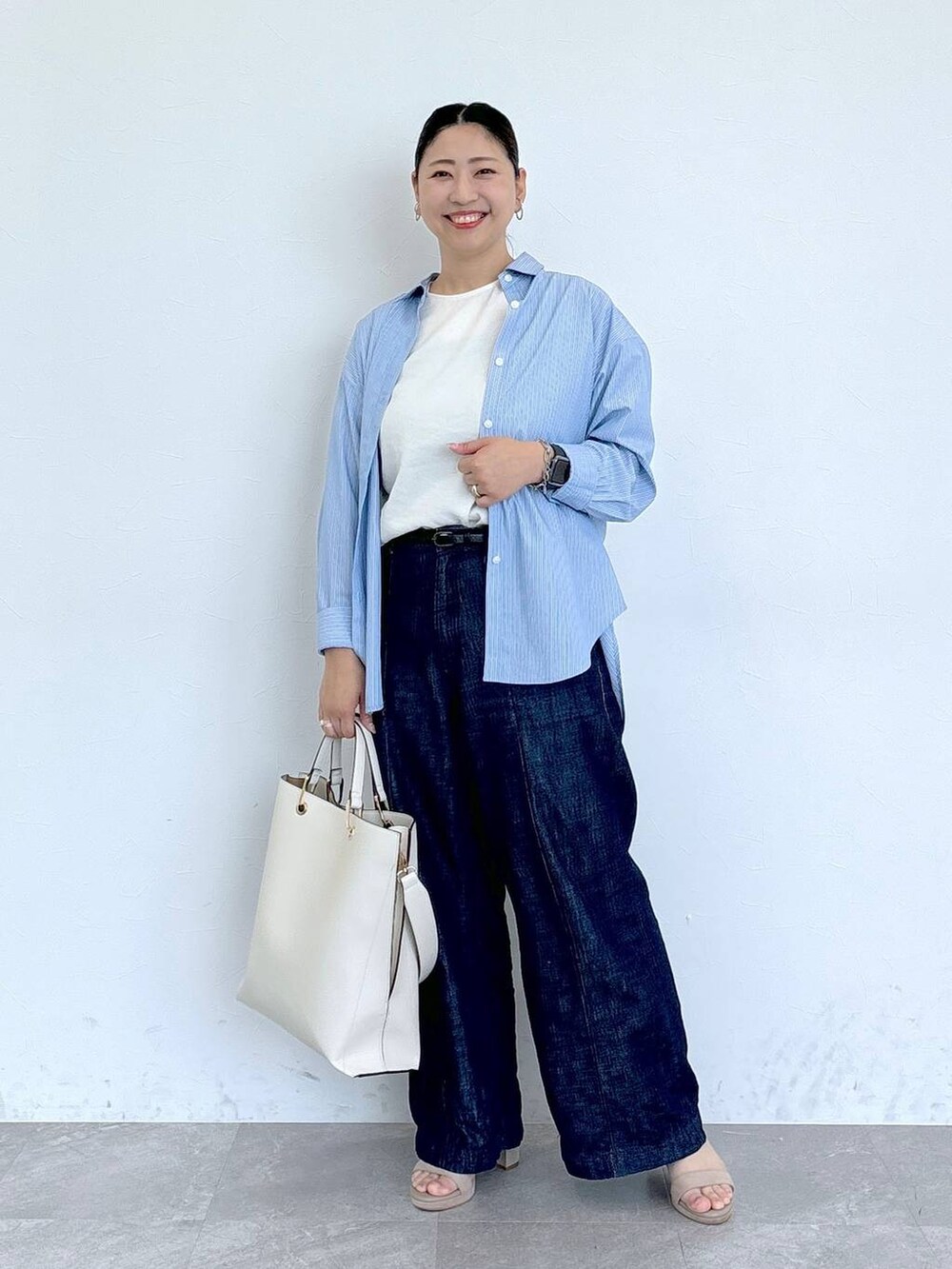 ブルー系のデニムパンツ、ホワイト系のシャツ/ブラウス、ベージュ系のサンダルを着用したレディースの夏コーディネートの2枚目の写真