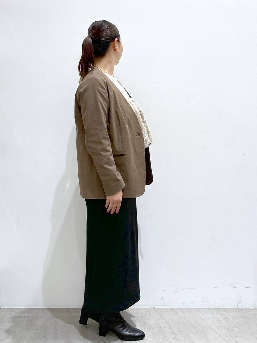 ブラック系のスカート、ブラック系のスカート、ホワイト系のTシャツ/カットソーを着用したレディースの秋コーディネートの5枚目の写真