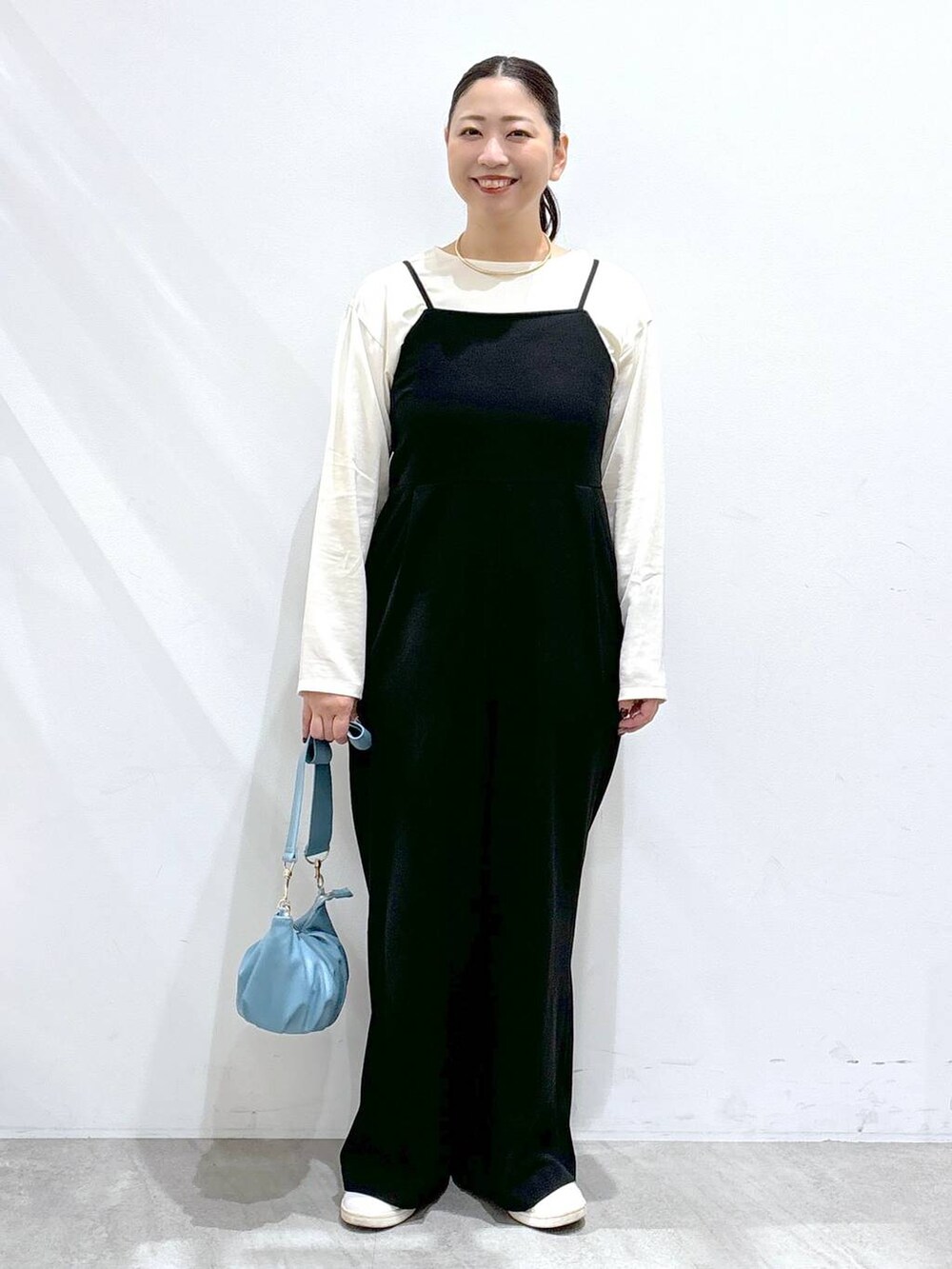 ホワイト系のシャツ/ブラウス、ブラック系のサロペット/オーバーオールを着用したレディースの秋コーディネートの2枚目の写真