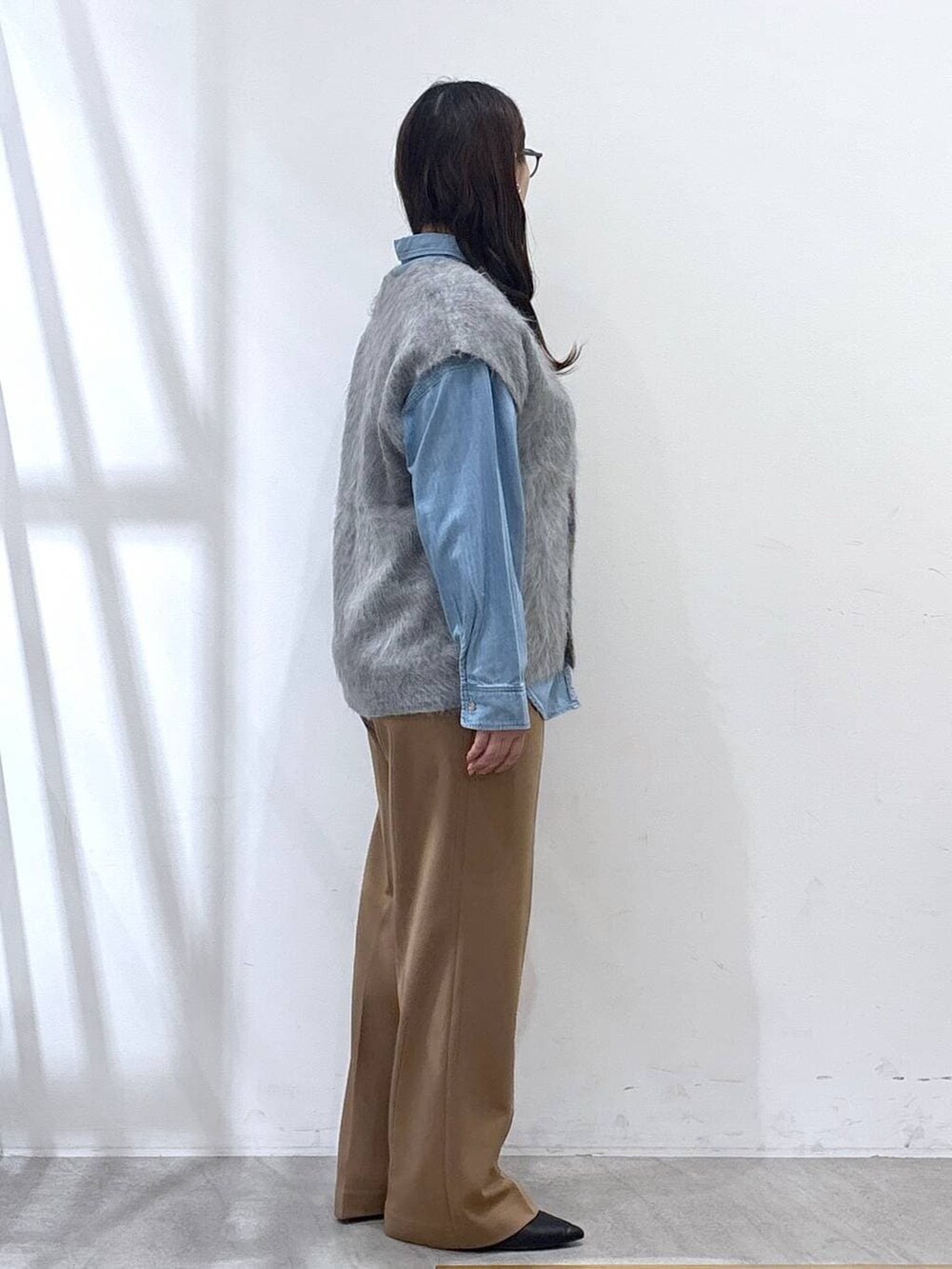 ブラック系のパンプス、ブルー系のシャツ/ブラウス、イエロー系のその他パンツを着用したレディースの冬コーディネートの4枚目の写真