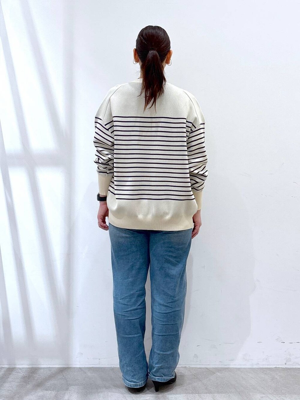 ブルー系のデニムパンツ、ブルー系のカーディガン/ボレロ、グレー系のTシャツ/カットソーを着用したレディースの春コーディネートの4枚目の写真