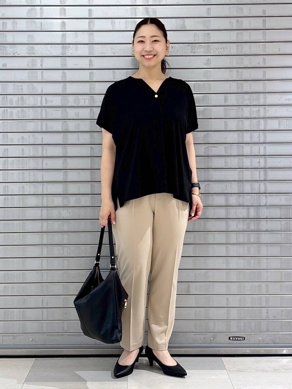 ブラック系のパンプス、ブラック系のハンドバッグ、ベージュ系のその他パンツを着用したレディースの春コーディネートの2枚目の写真