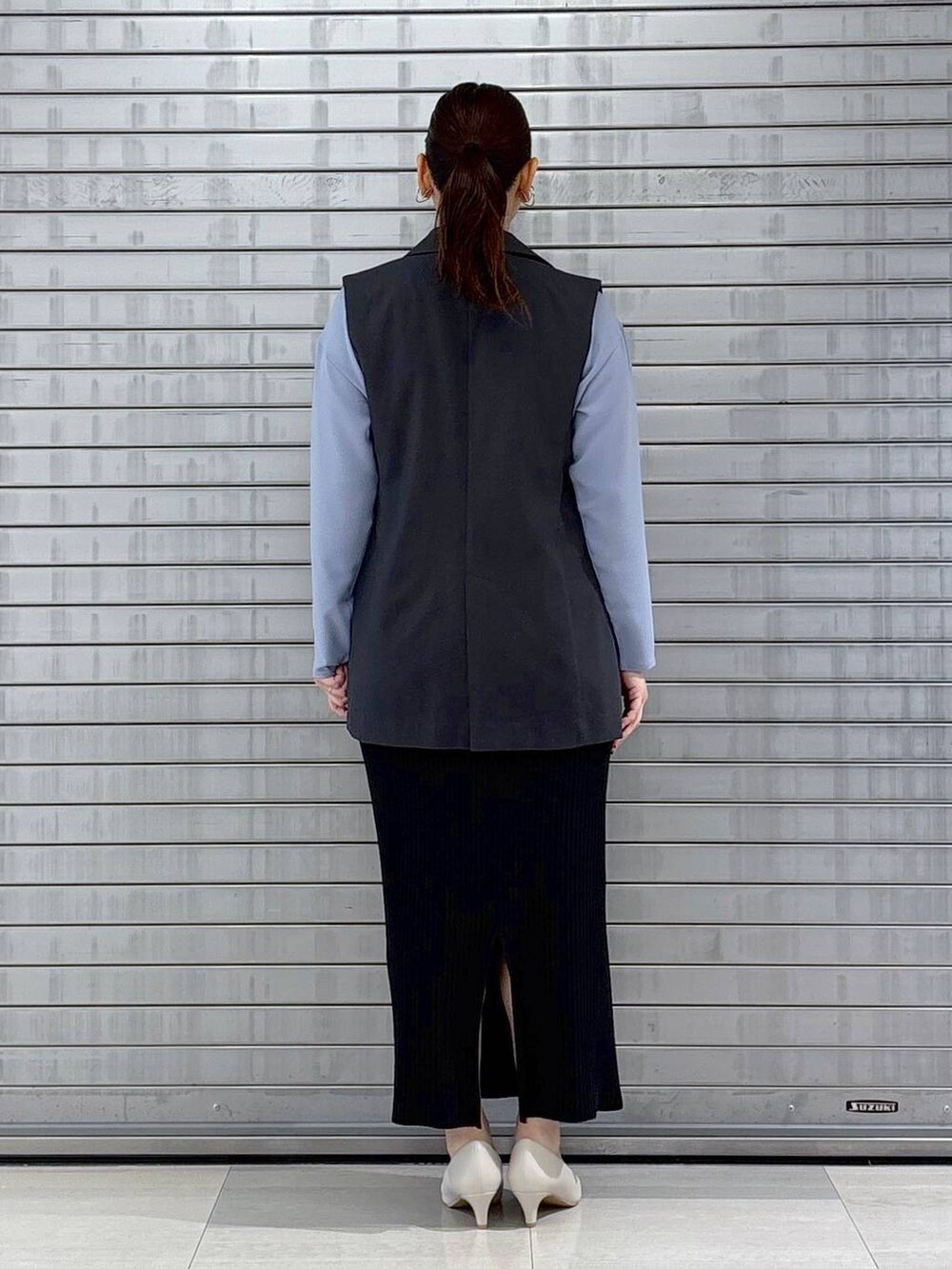 ベージュ系のハンドバッグ、グレー系のベスト、ブルー系のシャツ/ブラウスを着用したレディースの春コーディネートの4枚目の写真