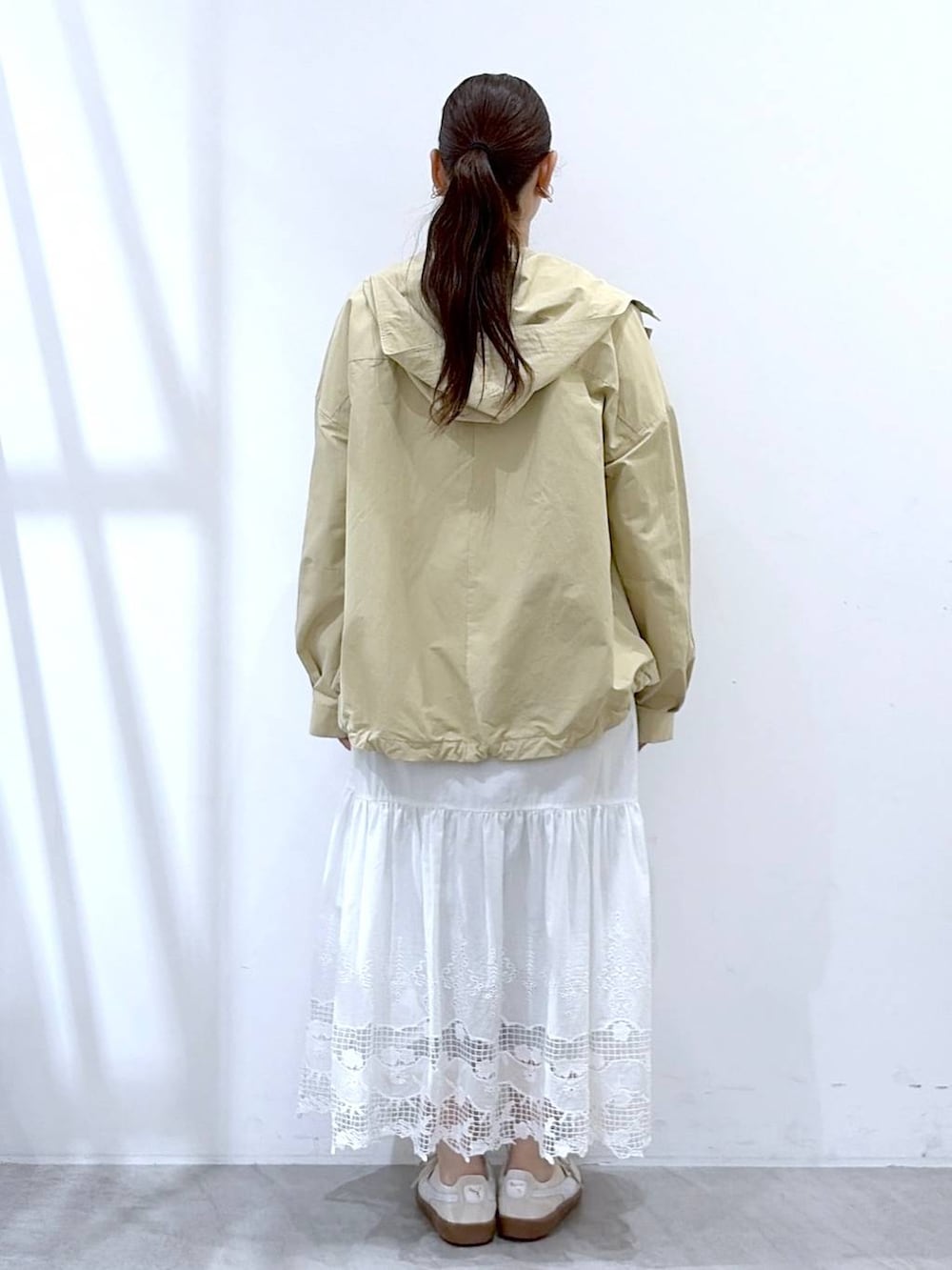 ブラウン系のTシャツ/カットソー、ブラック系のバックパック/リュック、ホワイト系のスカートを着用したレディースの春コーディネートの4枚目の写真