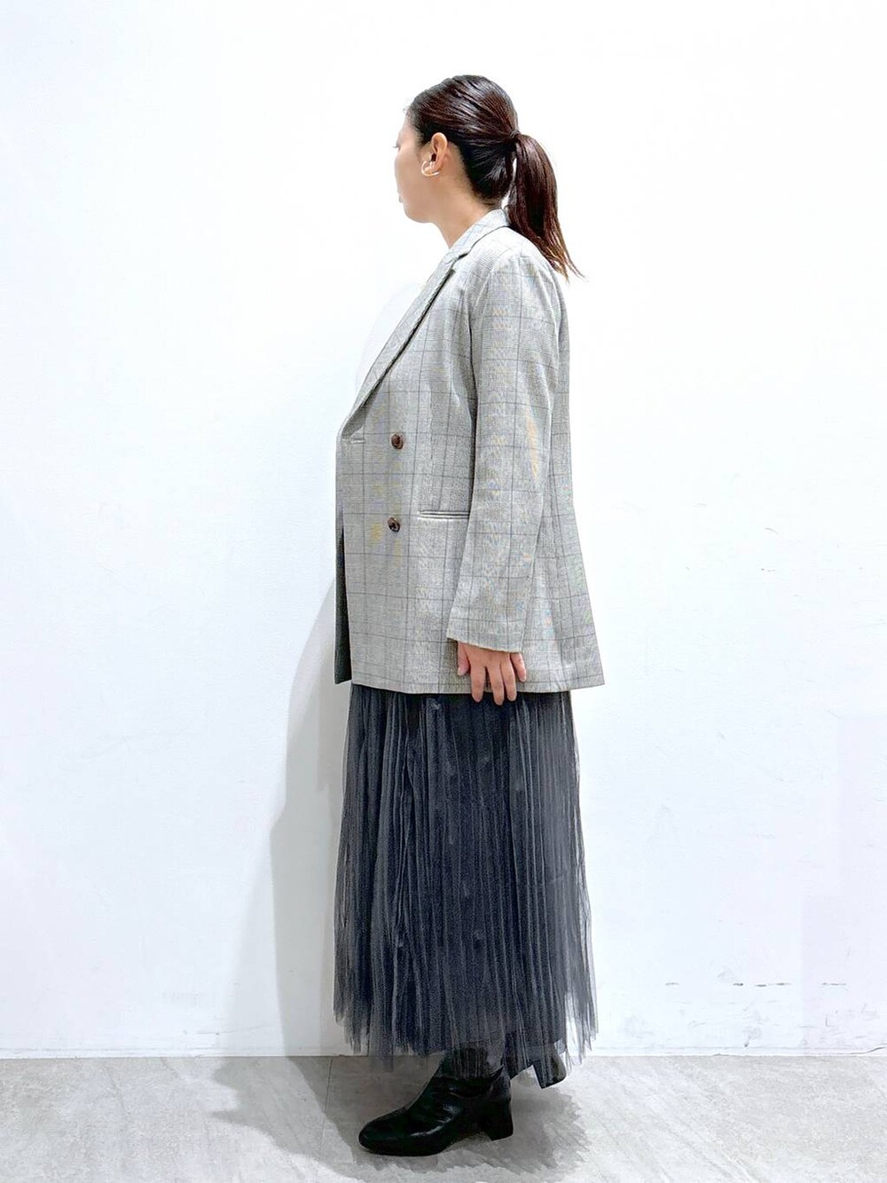 ブラック系のその他アウター、ブラック系のハンドバッグ、グレー系のスカートを着用したレディースの秋コーディネートの3枚目の写真