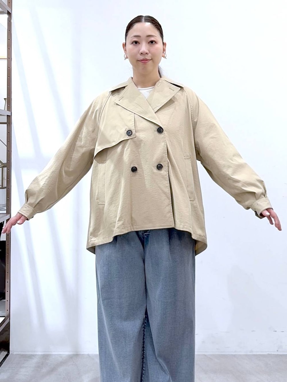 ホワイト系のニット/セーター、ブルー系のデニムパンツ、ブラック系のハンドバッグを着用したレディースの春コーディネートの6枚目の写真