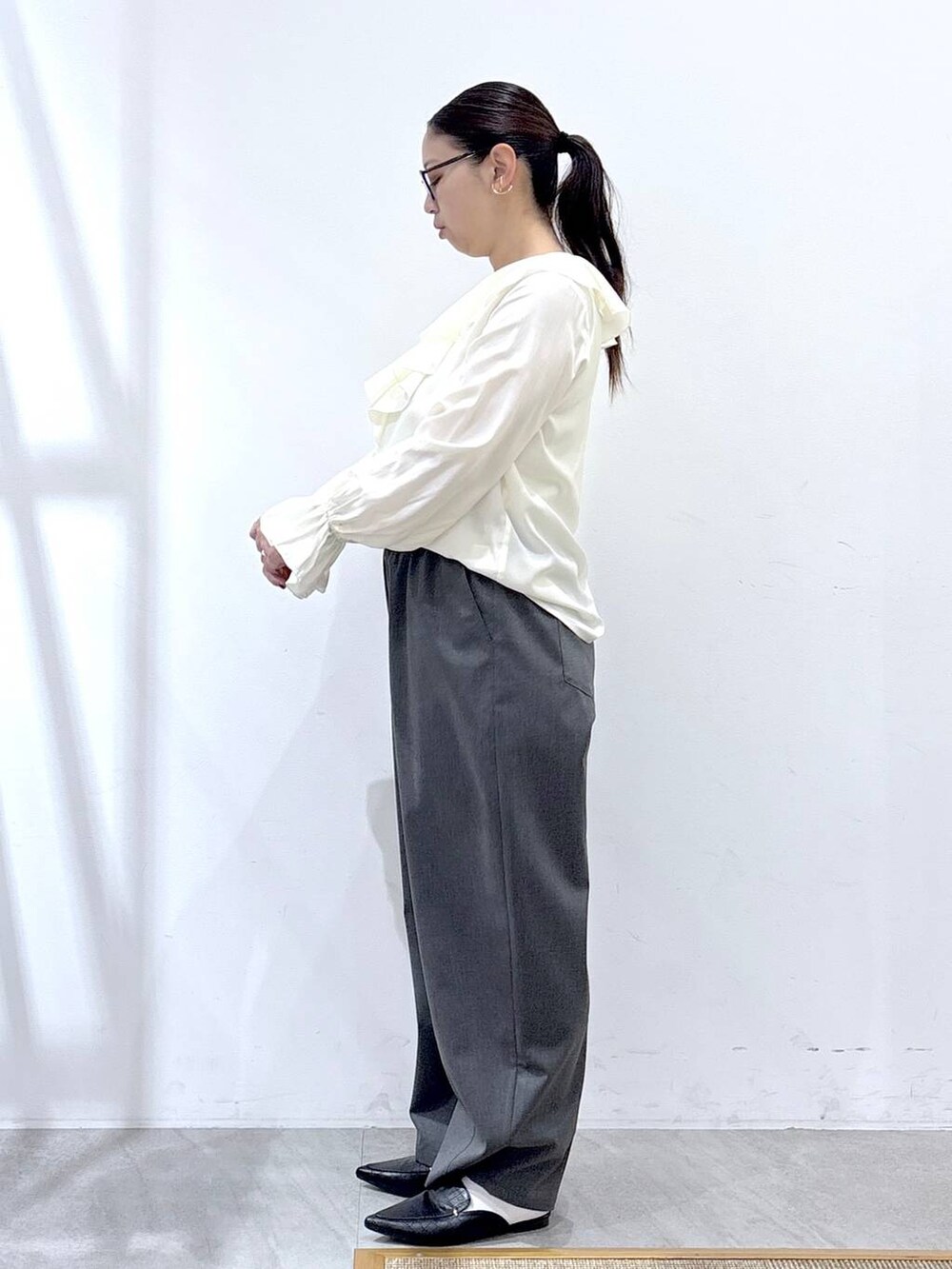 ブラック系のパンプス、ブルー系のカーディガン/ボレロ、ブラック系のハンドバッグを着用したレディースの冬コーディネートの3枚目の写真