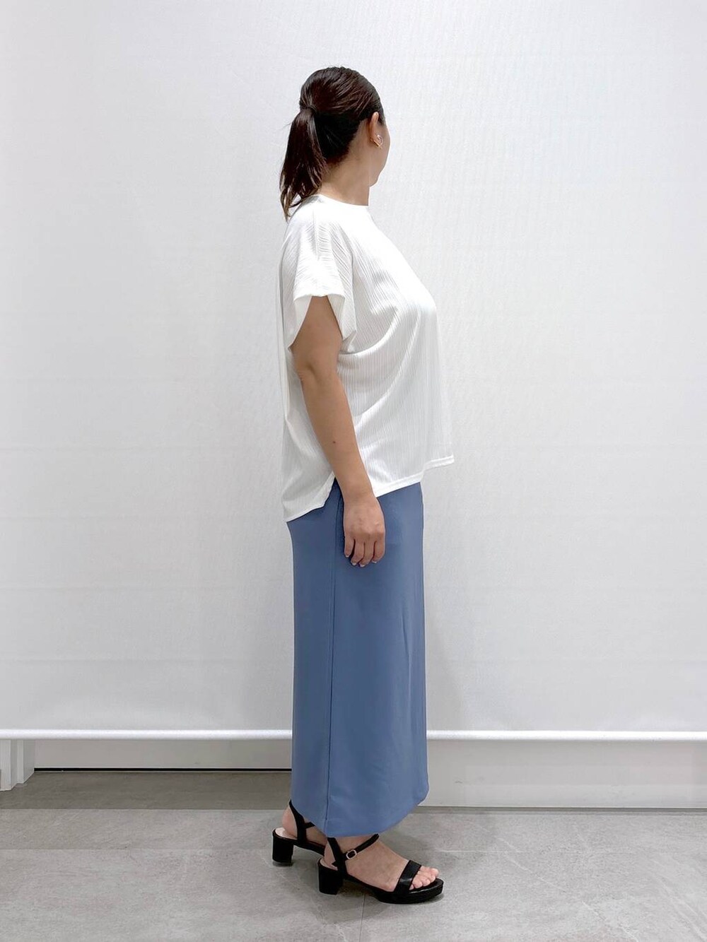ホワイト系のTシャツ/カットソー、ブラック系のサンダル、ブルー系のスカートを着用したレディースの夏コーディネートの4枚目の写真