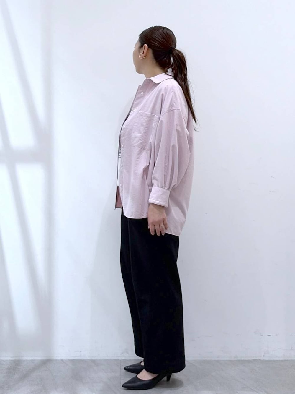 ブラック系のその他パンツ、ブラック系のトートバッグ、ピンク系のシャツ/ブラウスを着用したレディースの春コーディネートの3枚目の写真