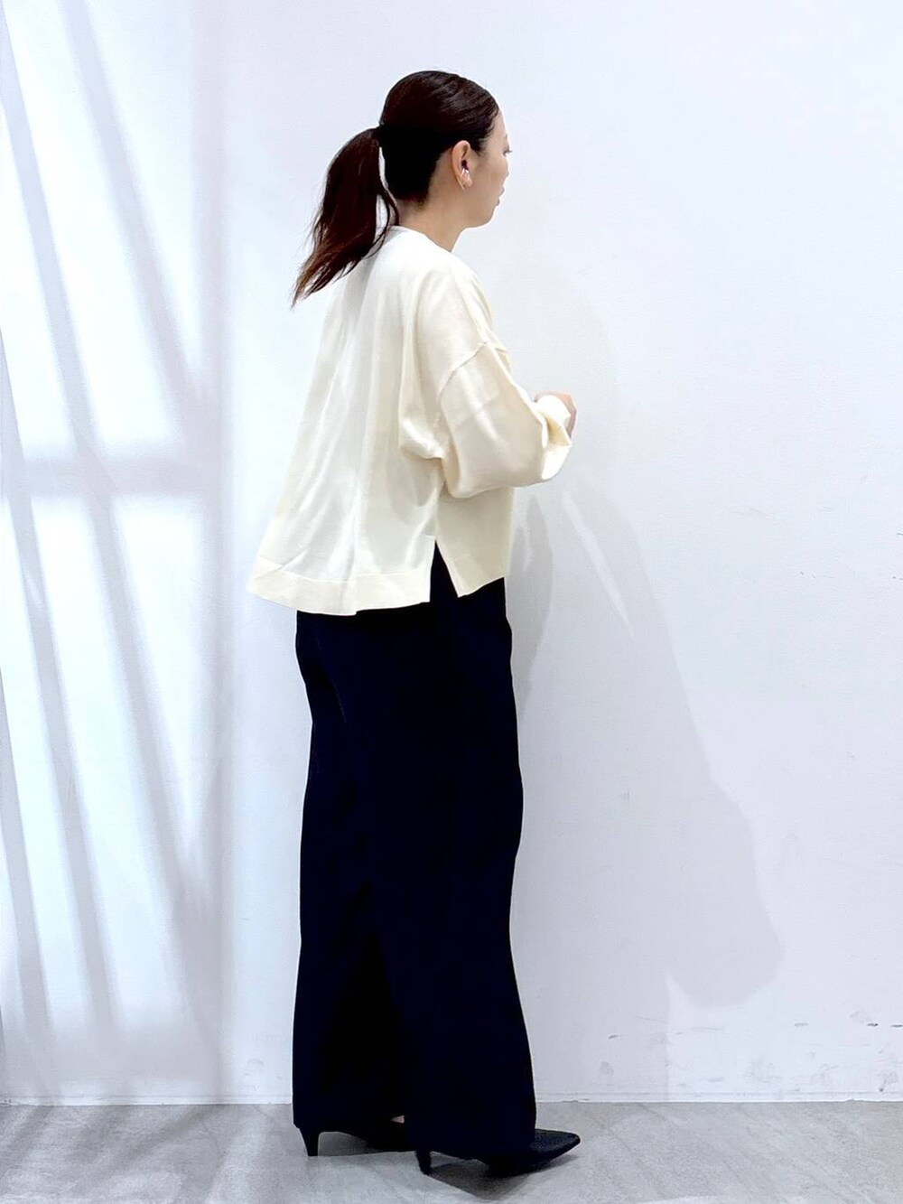 ホワイト系のニット/セーター、ブルー系のその他パンツを着用したレディースの春コーディネートの5枚目の写真