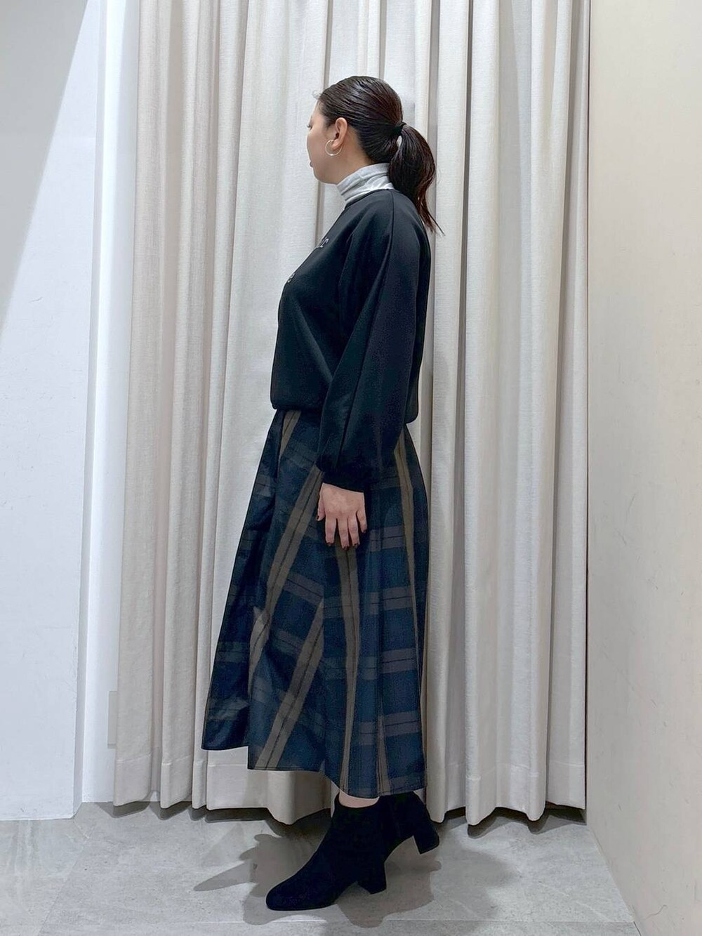 ブラック系のスウェット、ホワイト系のTシャツ/カットソー、グレー系のブーツを着用したレディースの秋コーディネートの3枚目の写真